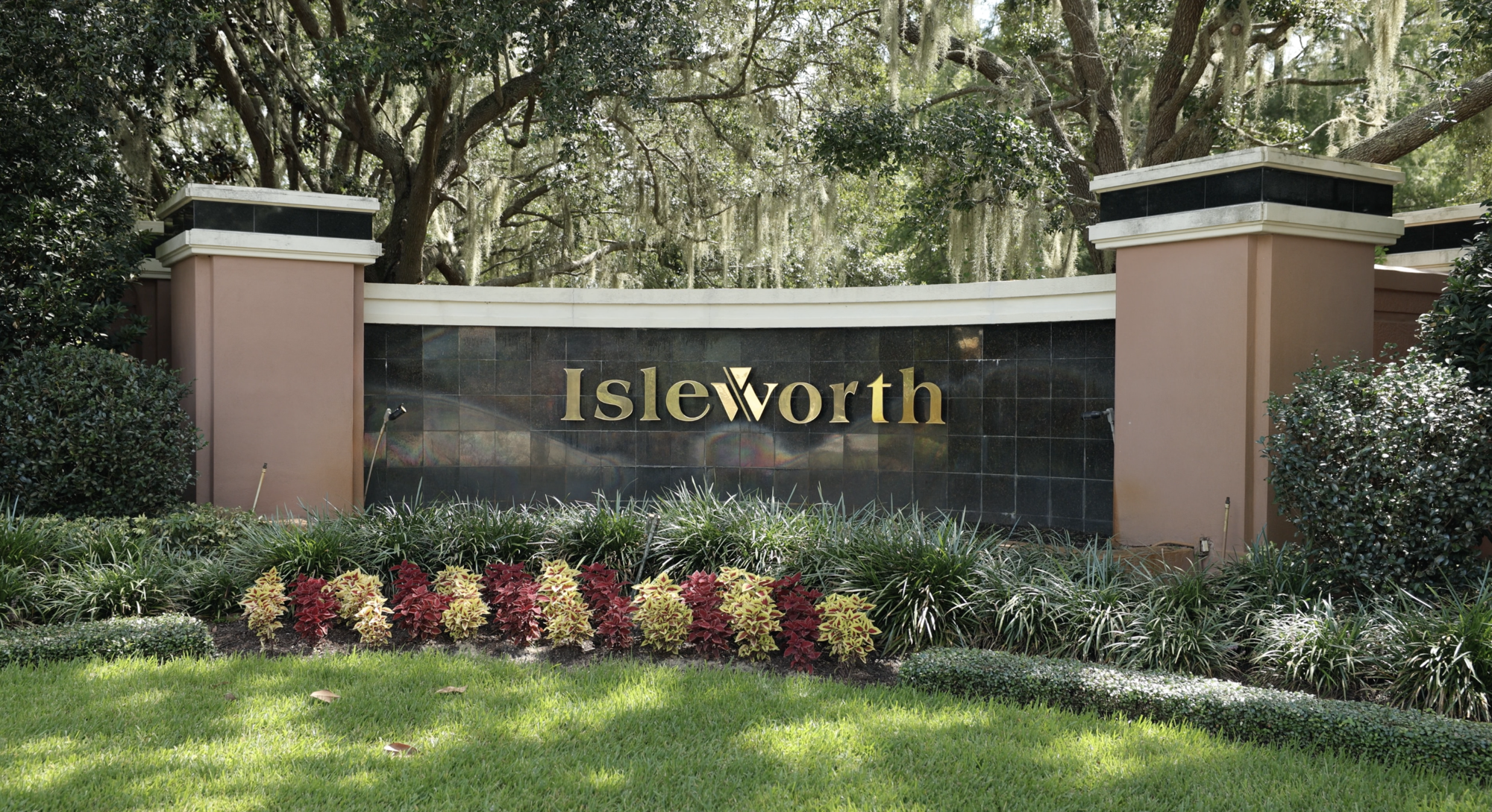 front of isleworth entrance sign with bushes